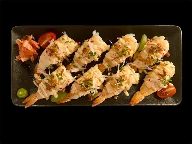 Flambierte Shrimp-Nigiri auf schwarzer Schieferplatte
