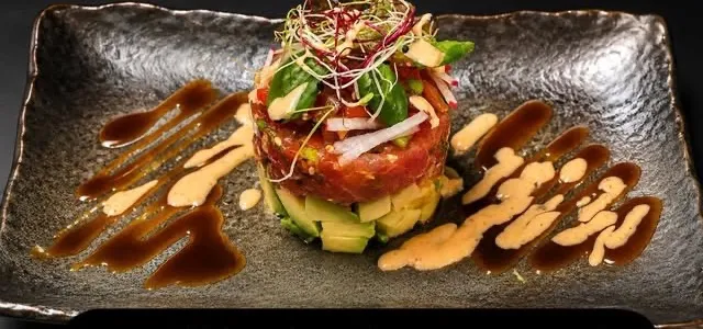 Thunfisch-Tartar mit Avocado auf dunkler Steinplatte